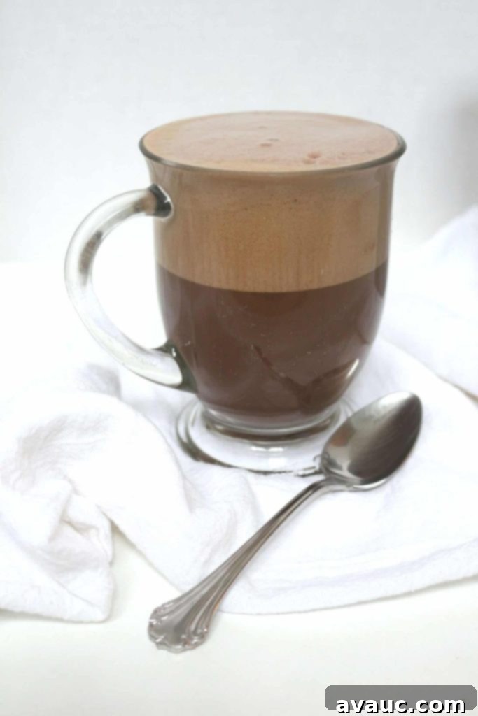 Cocoa Espresso Bliss 9 Super frothy dairy-free mocha latte in a clear glass, ready to be enjoyed