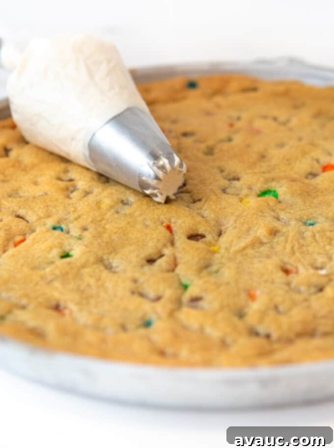 Ultimate Chewy M&M Cookie Cake 4 Large star piping tip and piping bag filled with smooth vanilla buttercream frosting, ready for decorating