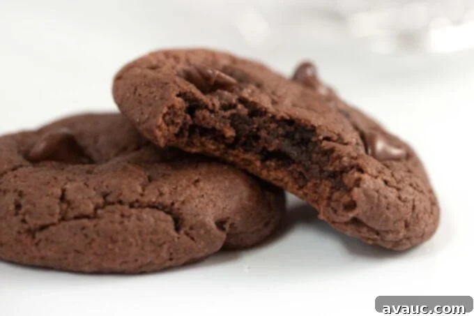 Easy Chocolate Cake Cookies 3 A close-up of a chocolate cake mix cookie with a bite taken out, revealing its soft, chewy, and intensely fudgy interior.