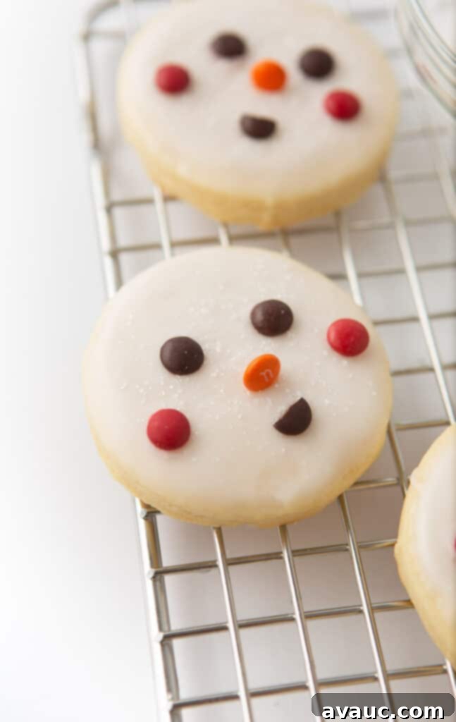 Quick and Easy Snowman Cookies 6 a decorated snowman cookie with M&M eyes, orange M&M nose, red M&M cheeks, and a brown M&M smile
