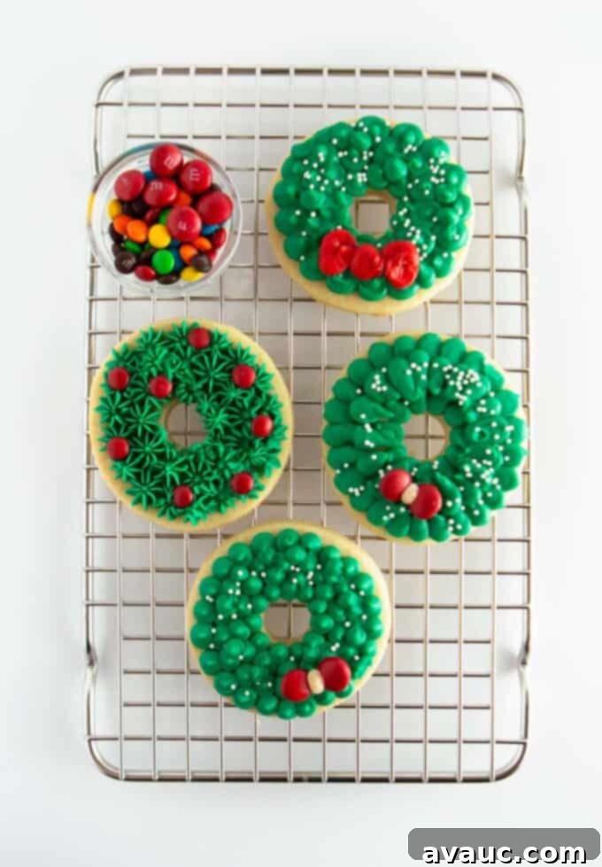 Cooling rack filled with freshly decorated green wreath cookies adorned with red M&Ms