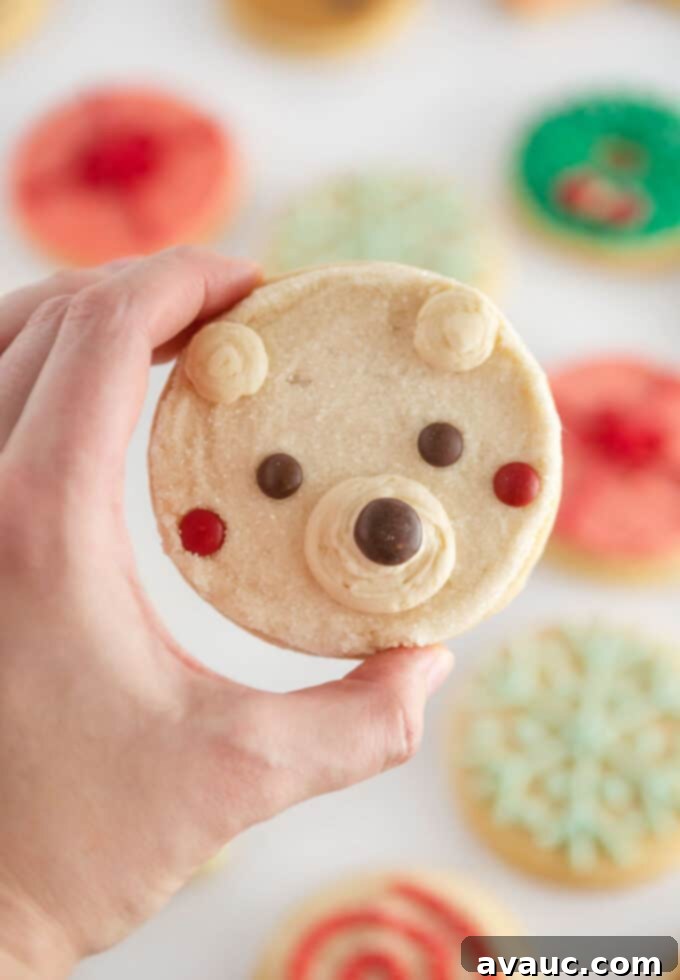 Cute and Simple Polar Bear Cookies 3 A hand holding an easy polar bear cookie, decorated with M&M candy, highlighting the cute and simple design.