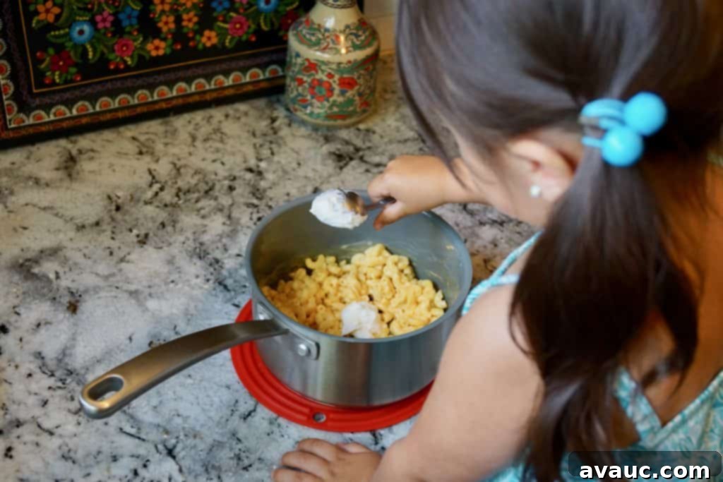5 Smart Ways to Supercharge Boxed Mac and Cheese for Growing Kids 3 My daughter enthusiastically making boxed mac and cheese, a fun kitchen activity