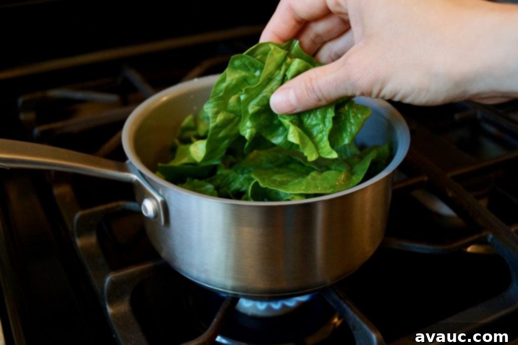 Steaming fresh spinach, preparing it for pureeing into mac and cheese
