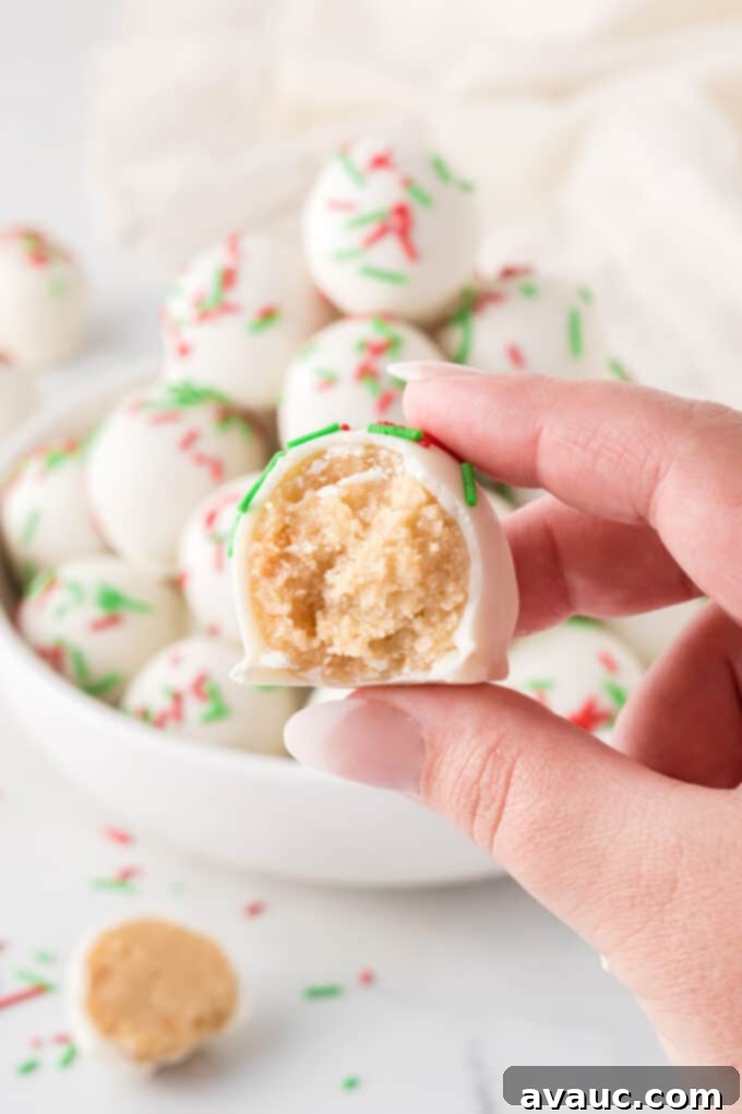 Gourmet Sugar Cookie Truffles 3 hand holding a sugar cookie truffle with a bite taken out, showing the soft interior