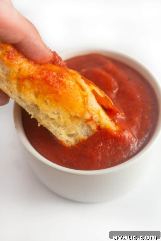 Pillowy One-Pan Pizza 12 dipping sheet pan pizza in pizza sauce