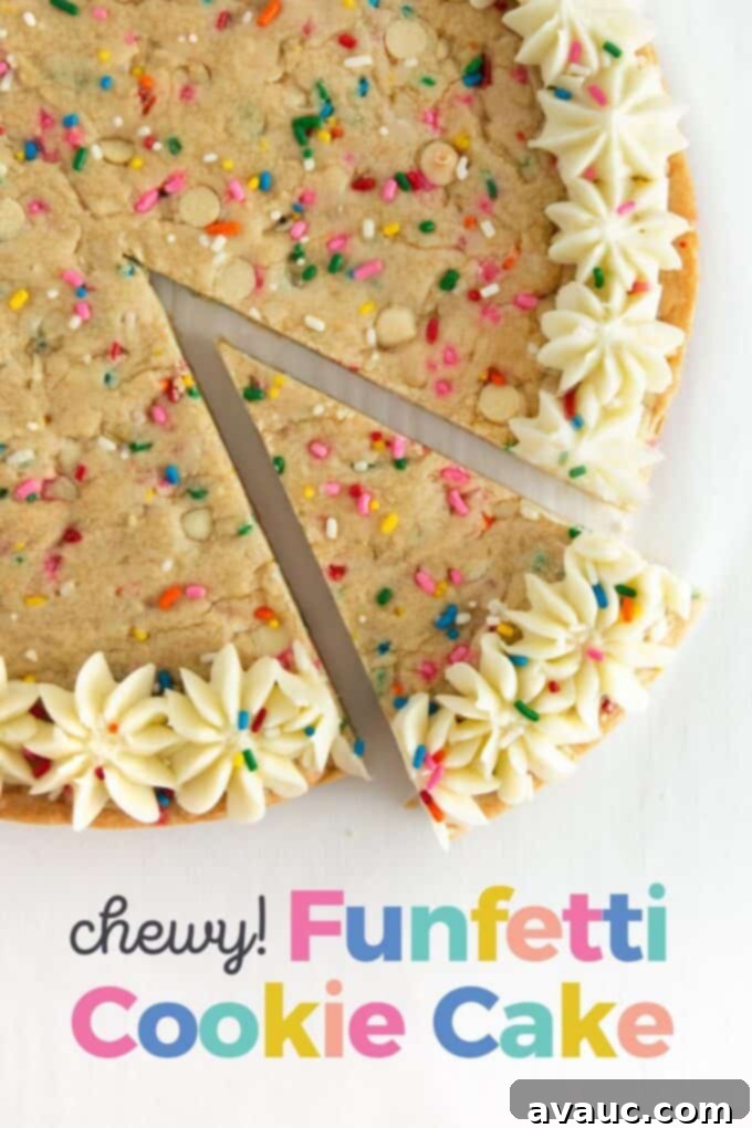 Vibrant Chewy Funfetti Cookie Cake 2 A slice of funfetti cookie cake topped with vanilla buttercream and colorful sprinkles, on a white plate.