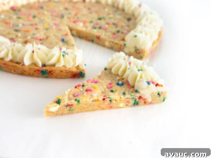Vibrant Chewy Funfetti Cookie Cake 4 A hand drizzling extra sprinkles onto a freshly baked funfetti cookie cake.