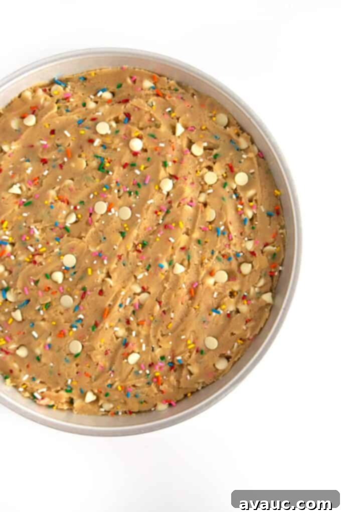 Vibrant Chewy Funfetti Cookie Cake 8 Pressing the cookie dough evenly into a greased round cookie cake pan.