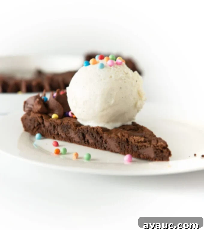 Decadent Triple Chocolate Cookie Cake 3 slice of triple chocolate cookie cake with scoop of vanilla ice cream and rainbow sprinkles