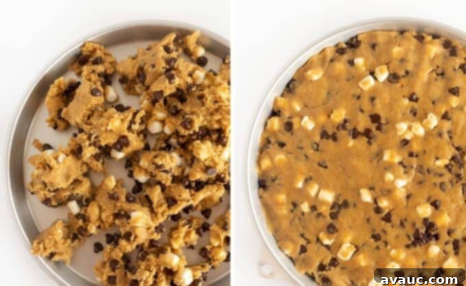 Campfire S'mores Cookie Cake 9 pressing smores cookie dough into round pan with a spatula
