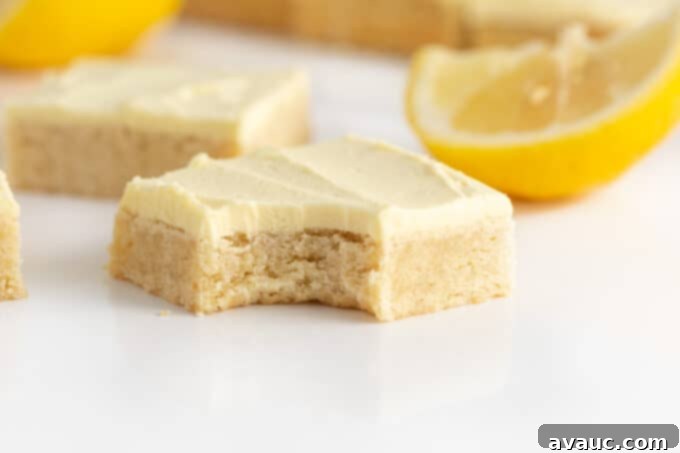 Single lemon sugar cookie bar with a bite taken out, revealing its incredibly soft, chewy texture.