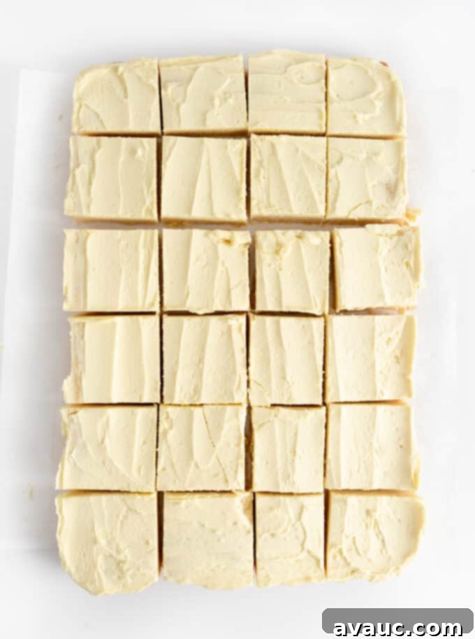 Overhead view of a tray of lemon sugar cookie bars, perfectly cut into 24 individual squares, ready for serving.
