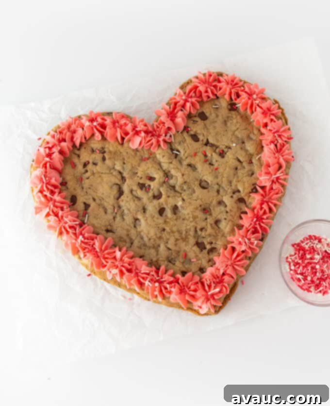 Decorated heart-shaped cookie cake with pink frosting and sprinkles for Valentine's Day