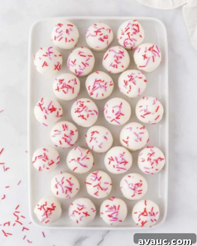 Valentines Day Sugar Cookie Truffles 11 A beautifully arranged tray of finished sugar cookie Valentine truffles, adorned with an array of red and pink sprinkles, ready to be served or gifted.