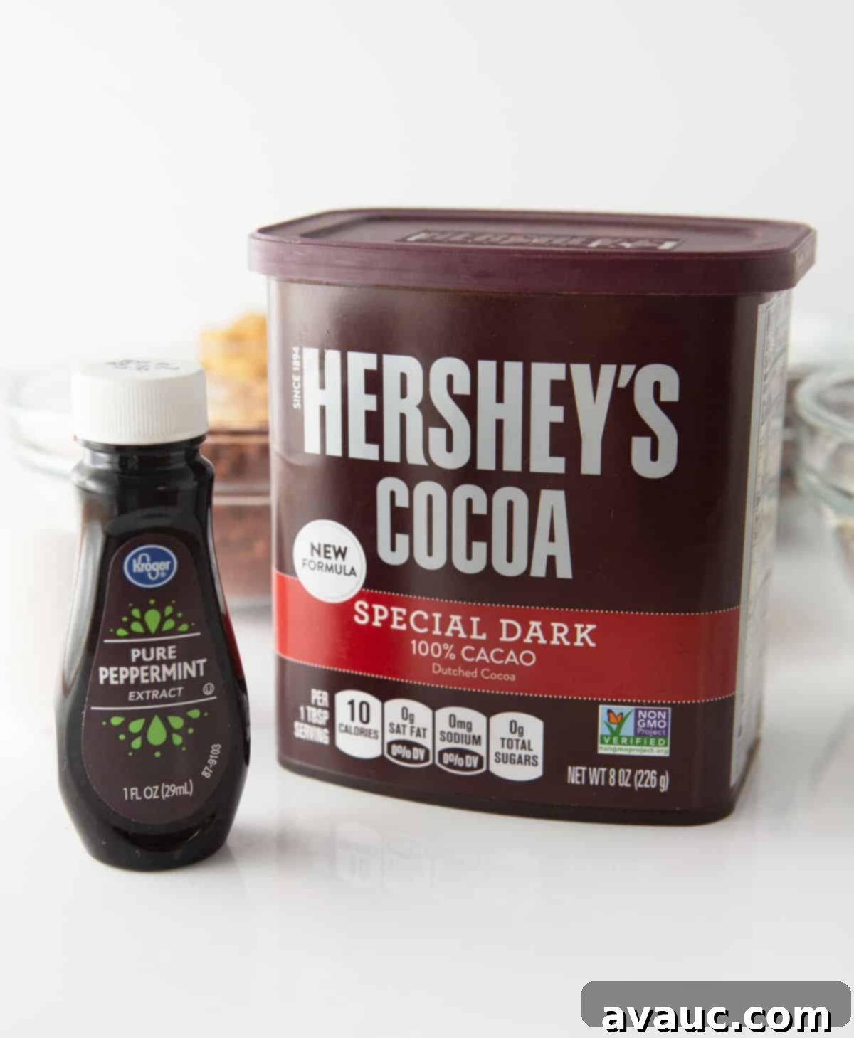 container of hershey's dark cocoa powder and a bottle of peppermint extract, essential flavor components for the thin mint cookie cake