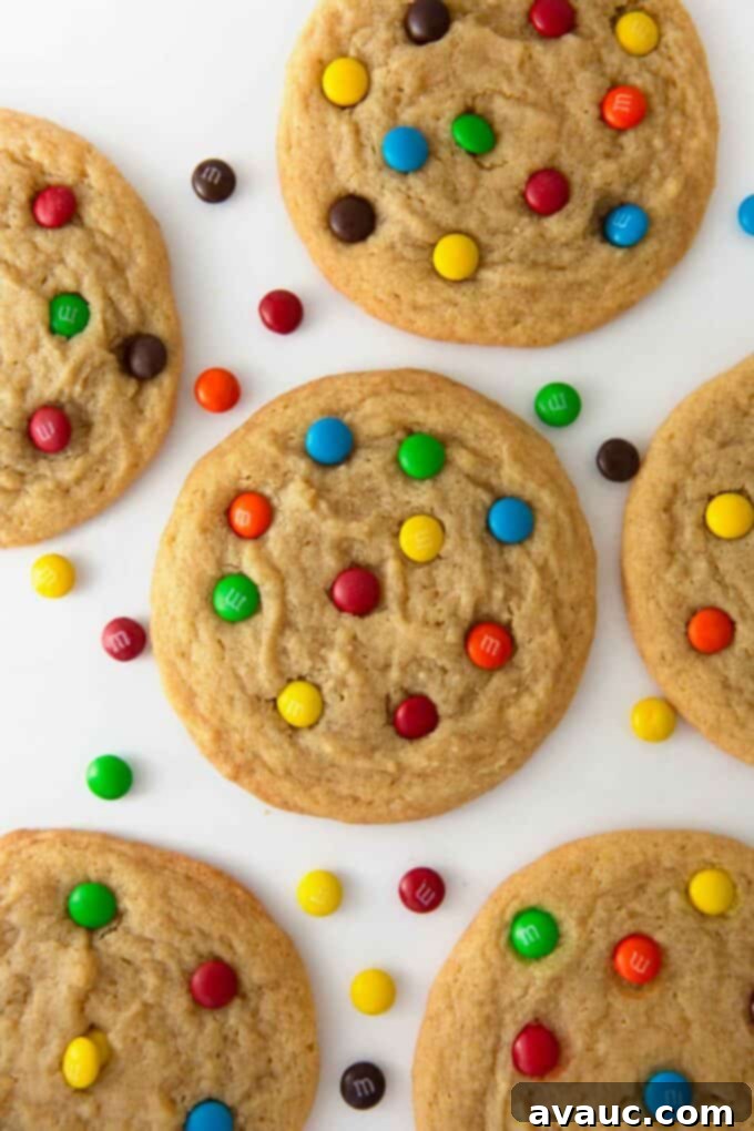 Mini M&M Chewy Bites 2 Freshly baked mini M&M cookies on a baking sheet, showcasing their soft texture and vibrant colors.