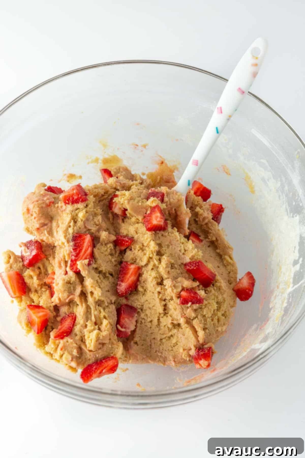 Cheesecake Filled Strawberry Cookies 5 Two glass bowls, one with creamy cookie dough and another with freshly sliced strawberries, ready to be combined to create the strawberry cookie base.