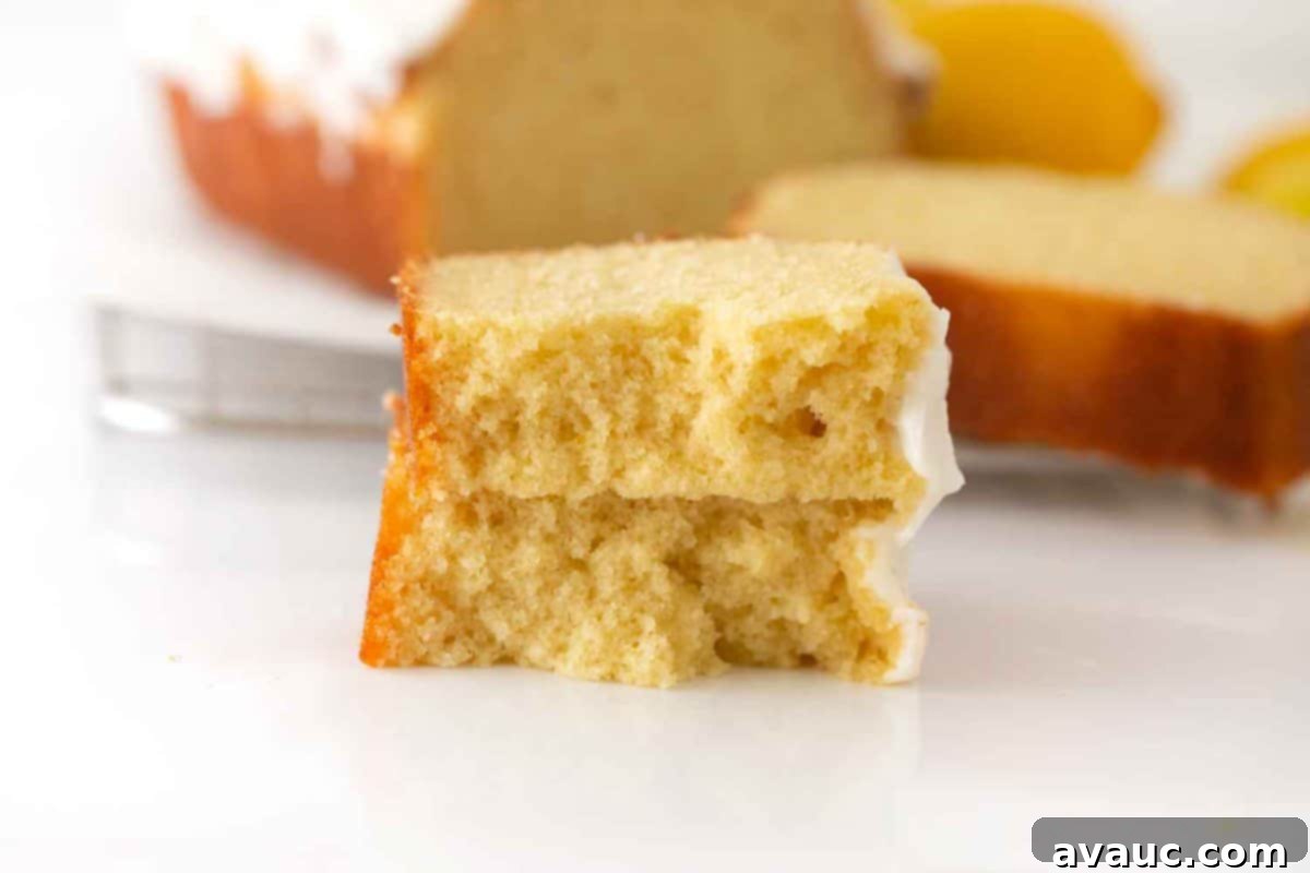 Starbucks-Inspired Lemon Loaf 4 A freshly baked lemon loaf, golden brown and glistening with lemon glaze, showcased beautifully on a rustic wooden board.