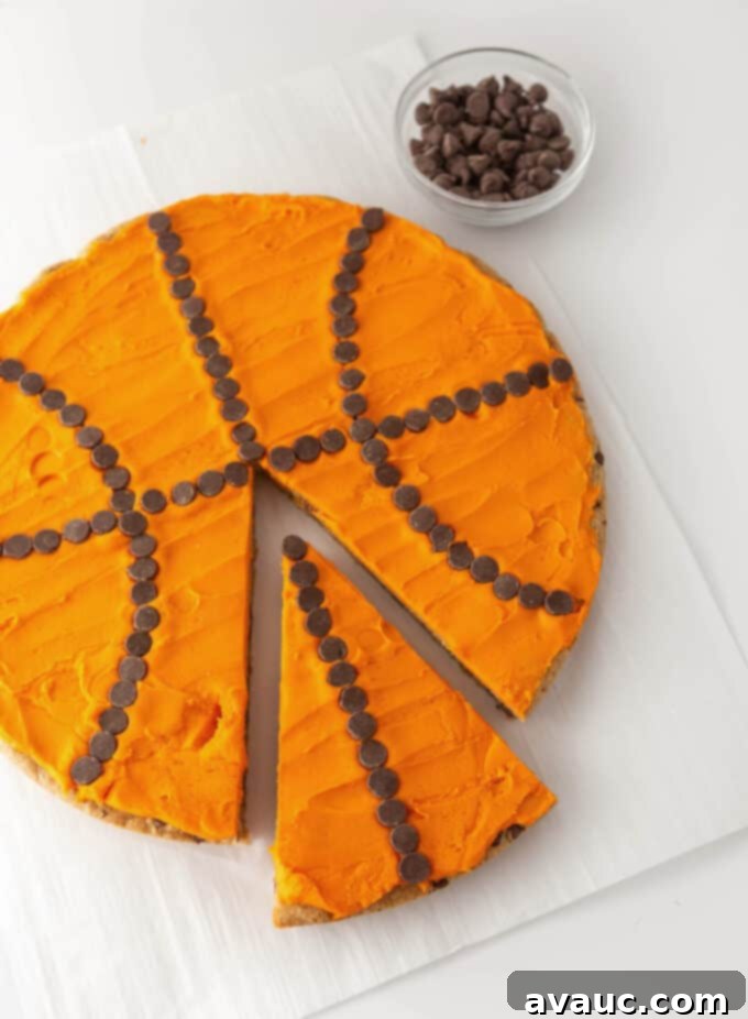 A beautifully decorated basketball cookie cake displayed on a white serving stand, ready for any celebration.