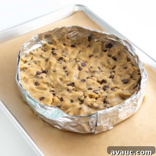 A perfectly baked, slightly golden cookie cake base in a round pan, before any frosting or decoration.