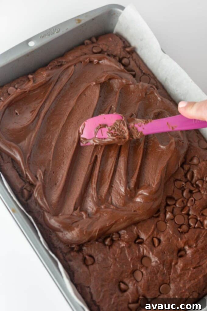 A tray of chocolate brownies with a generous layer of fudgy chocolate frosting.