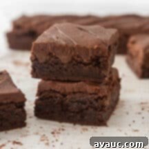 A close-up of a brownie with glossy chocolate frosting.