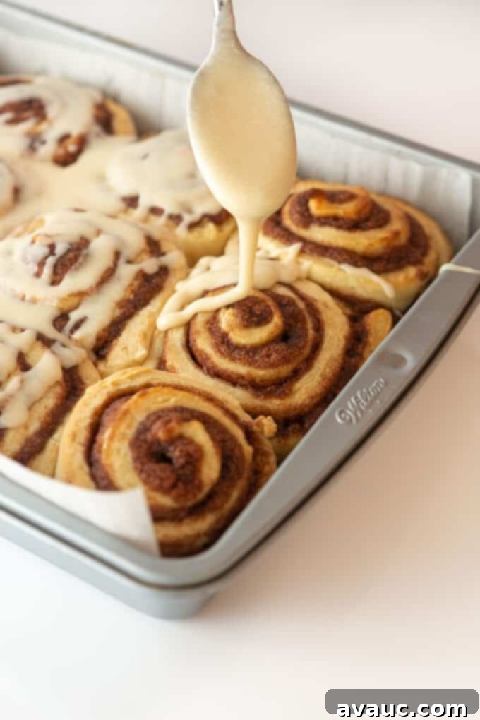 Cinnamon rolls drizzled generously with homemade vanilla icing, ready to be served.