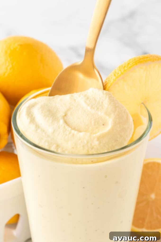 Homemade Chick-fil-A Frosted Lemonade 3 Glass of copycat Chick-fil-A frosted lemonade with a gold spoon, showcasing its creamy texture.