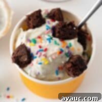 Cup of vibrant homemade cake batter ice cream with sprinkles, ready to eat.