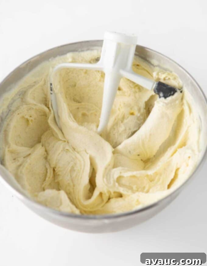 Vanilla ice cream being mixed with cake batter extract in a KitchenAid stand mixer.