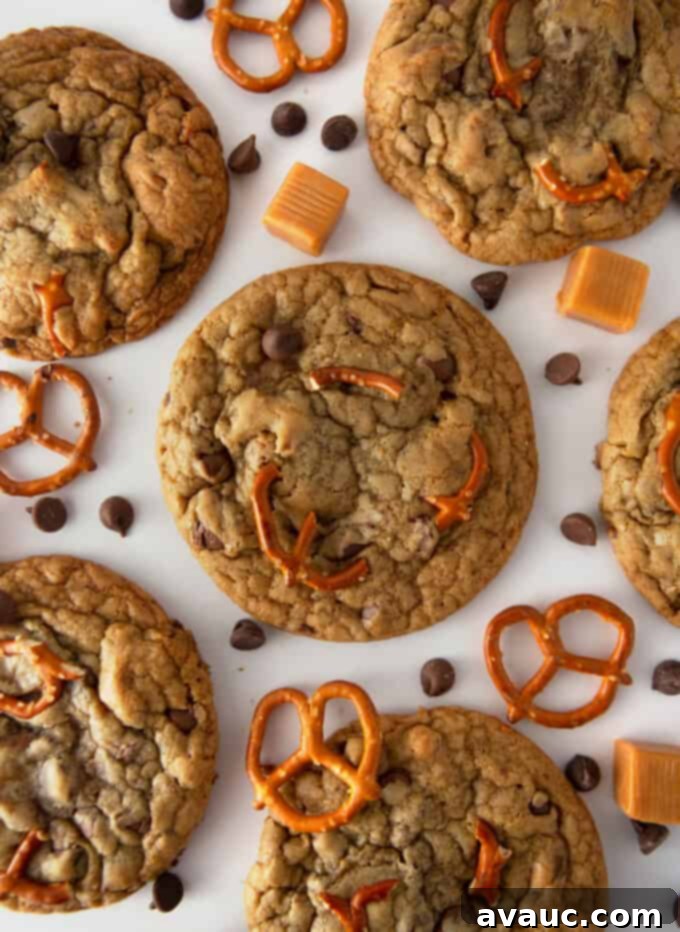 Freshly baked Panera-style Kitchen Sink Cookies loaded with chocolate chips, pretzels, and caramel on a cooling rack.