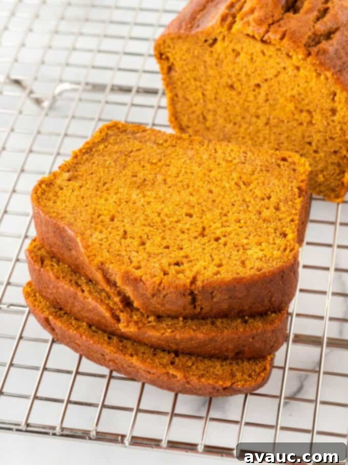 Stack of perfectly sliced, super moist copycat Starbucks pumpkin bread on a cooling rack, ready to be enjoyed.