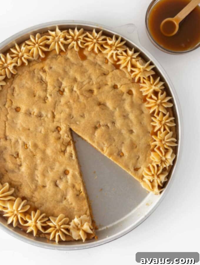 Decadent Chewy Butterscotch Chip Cookie Cake 2 Round butterscotch cookie cake with a slice already taken out, showcasing its soft, chewy texture and golden-brown edges.