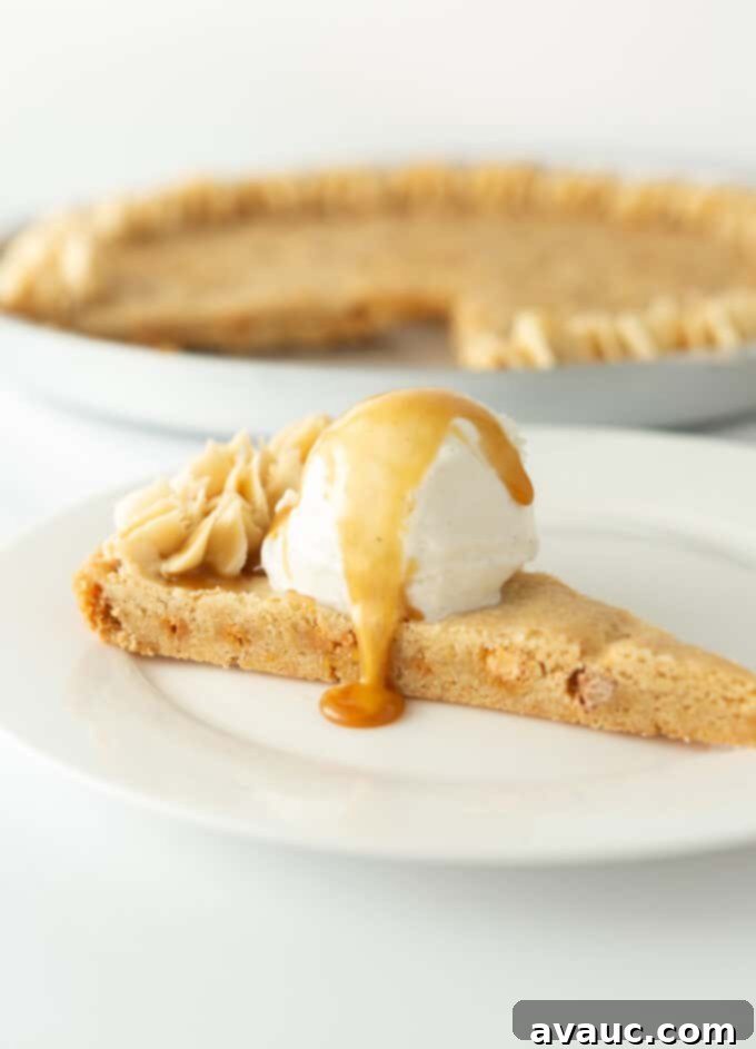 Decadent Chewy Butterscotch Chip Cookie Cake 8 A slice of butterscotch chip cookie cake served with a scoop of vanilla ice cream and an extra drizzle of caramel sauce.