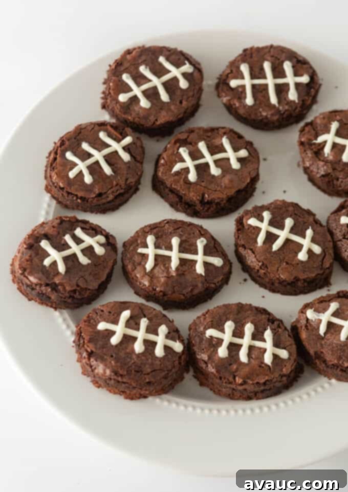 Touchdown Mini Brownies 2 decorated football shaped brownies on white plate, perfect for a Super Bowl party