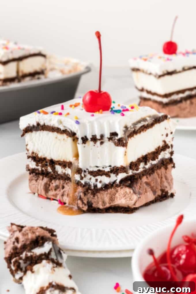 Dreamy Ice Cream Sandwich Cake 2 Square of ice cream sandwich cake on plate, with cherry on top, showcasing perfect layers