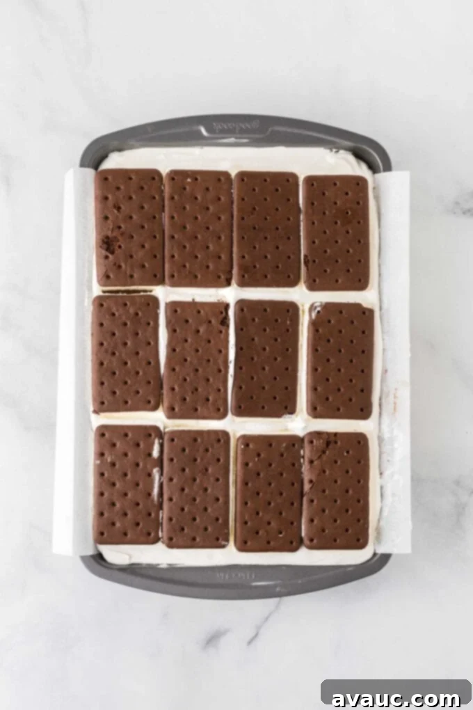 Dreamy Ice Cream Sandwich Cake 11 Overhead view of ice cream sandwich cake with the second layer of vanilla ice cream sandwiches added
