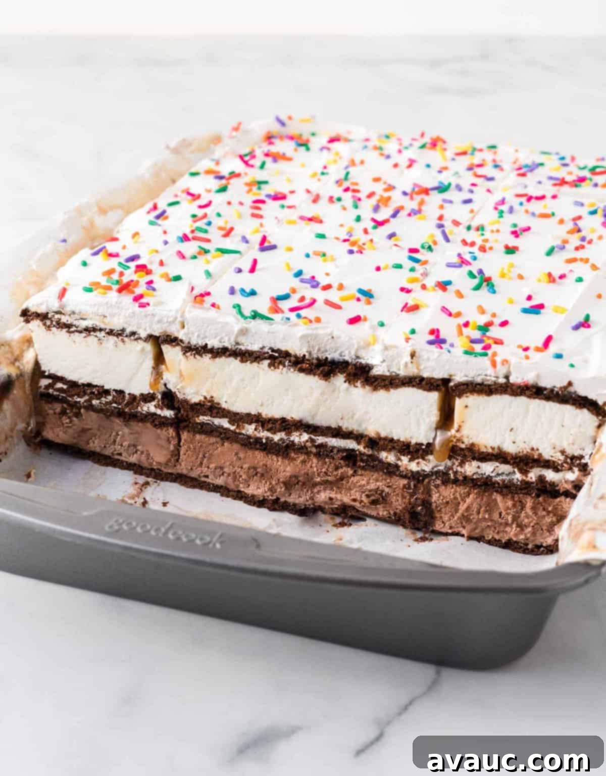 Dreamy Ice Cream Sandwich Cake 16 Cut ice cream sandwich cake in pan, showing perfectly distinct layers of ice cream, fudge, caramel, and whipped topping