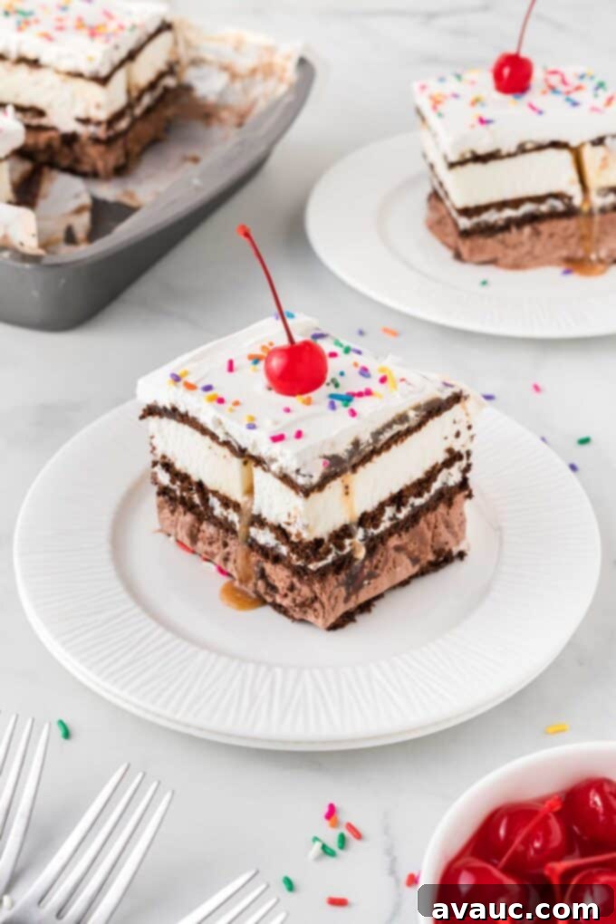 Dreamy Ice Cream Sandwich Cake 17 Two squares of ice cream sandwich cake on plates, garnished with cherries and sprinkles