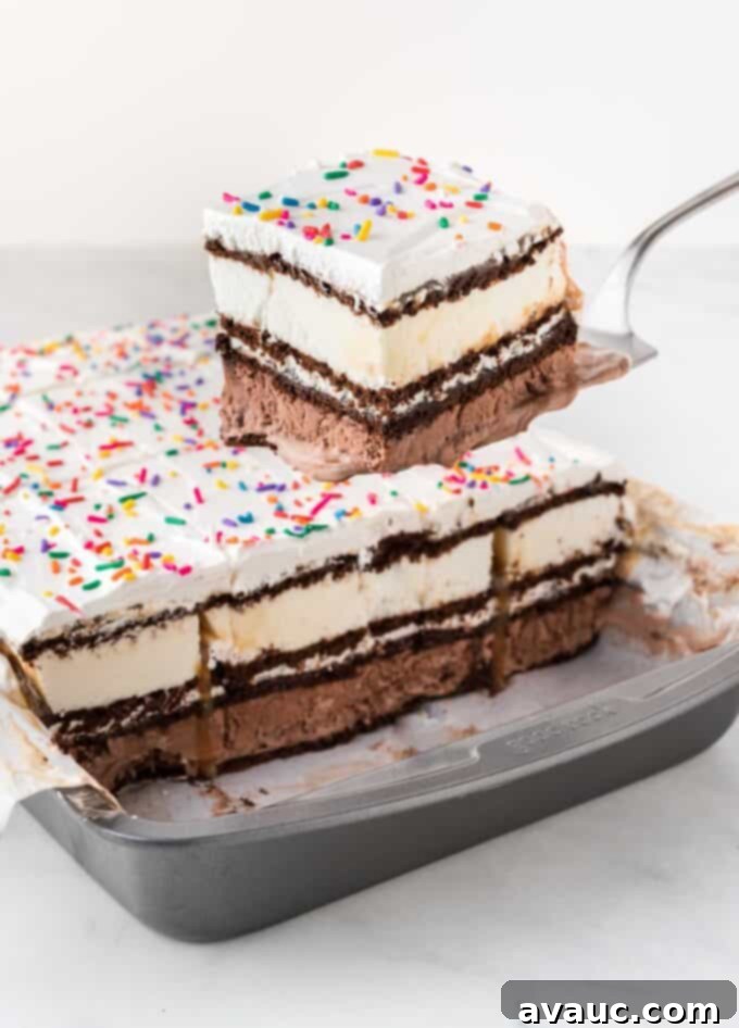Dreamy Ice Cream Sandwich Cake 3 Spatula removing square of ice cream sandwich cake from pan, showing layers clearly