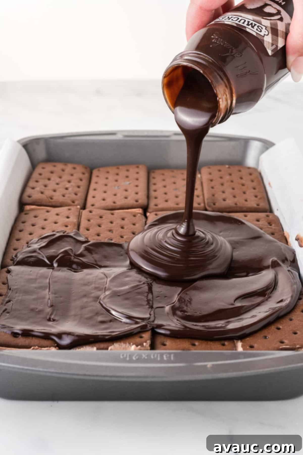 Dreamy Ice Cream Sandwich Cake 7 Pouring warm fudge sauce generously onto the chocolate ice cream sandwich layer