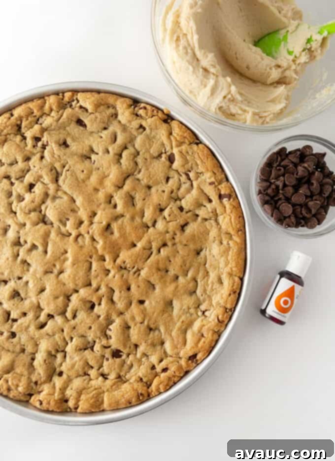 Spooktacular Easy Pumpkin Cookie Cake 4 close-up of orange frosting being spread on a cookie cake