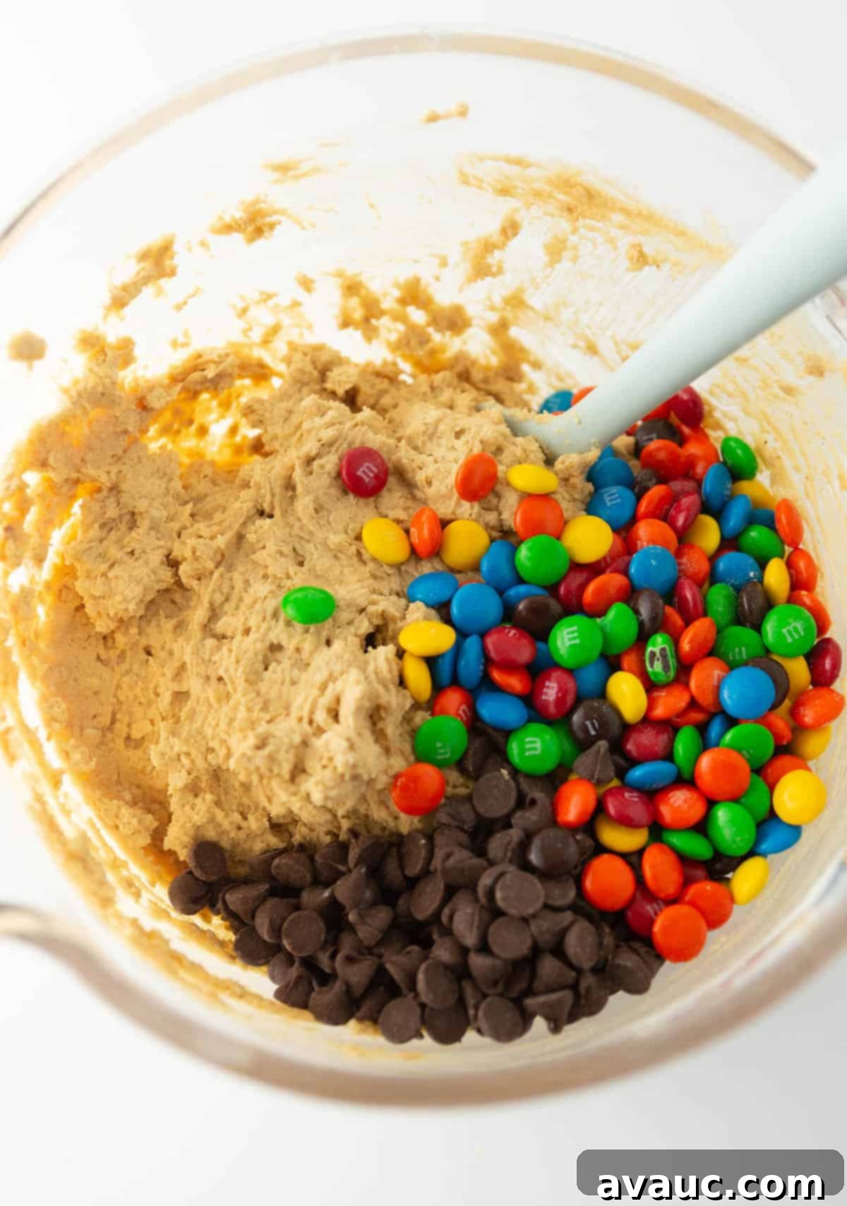 Large bowl of monster cookie dough with chocolate chips and M&M's, ready for scooping