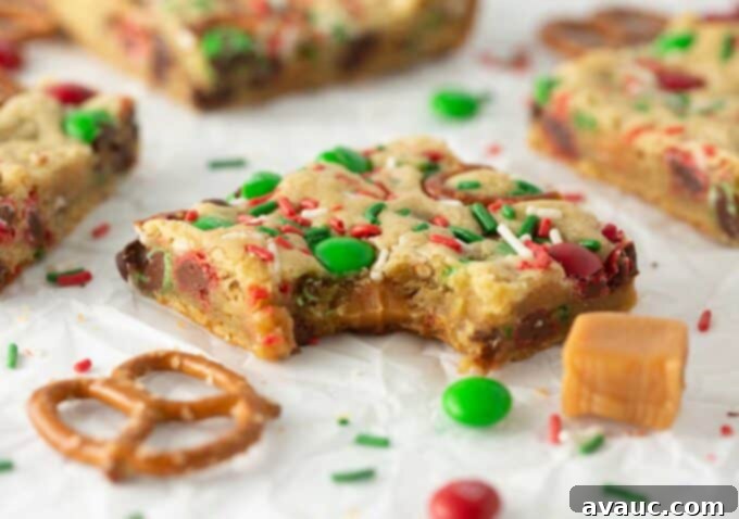 Festive Cookie Squares 3 Close-up of a festive M&M Christmas cookie bar with a bite taken out, showing the soft interior.