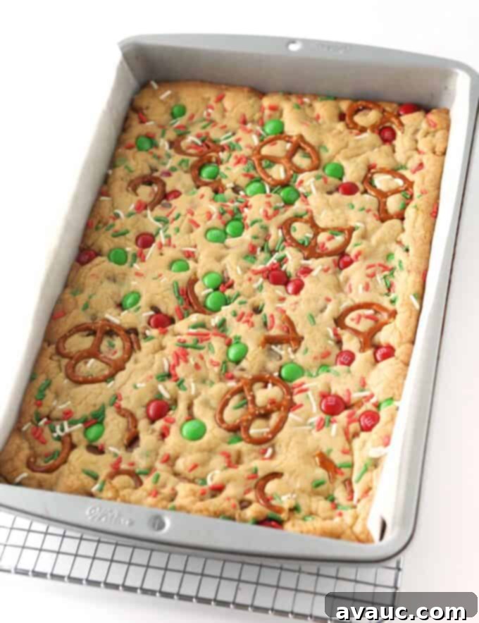 Festive Cookie Squares 9 Freshly baked Christmas cookie bars in a pan, cooling on a rack, edges lightly golden brown.