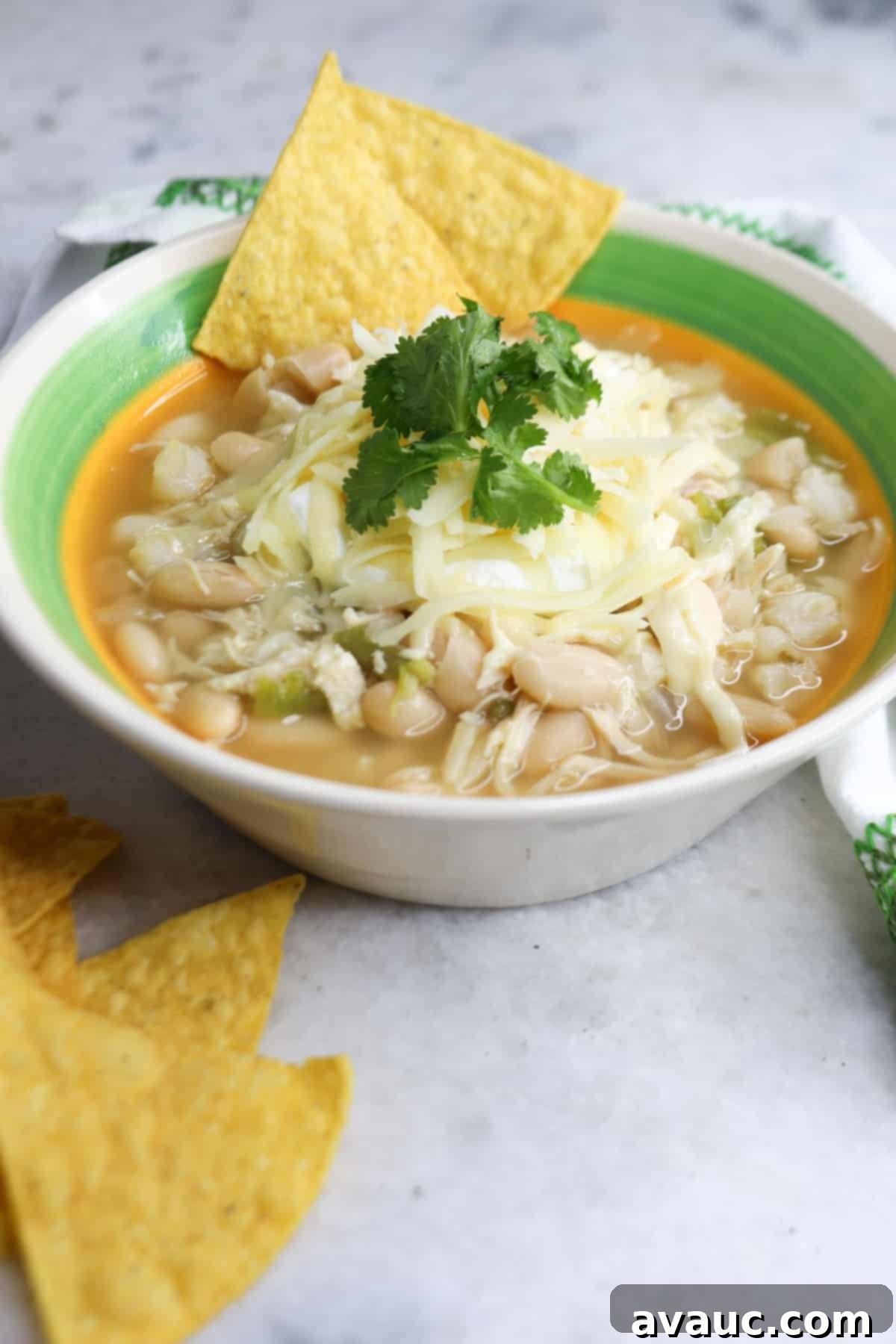 Foolproof White Chicken Chili with Hominy 2 Bowl of white chicken chili with hominy with garnishes and tortillas chips