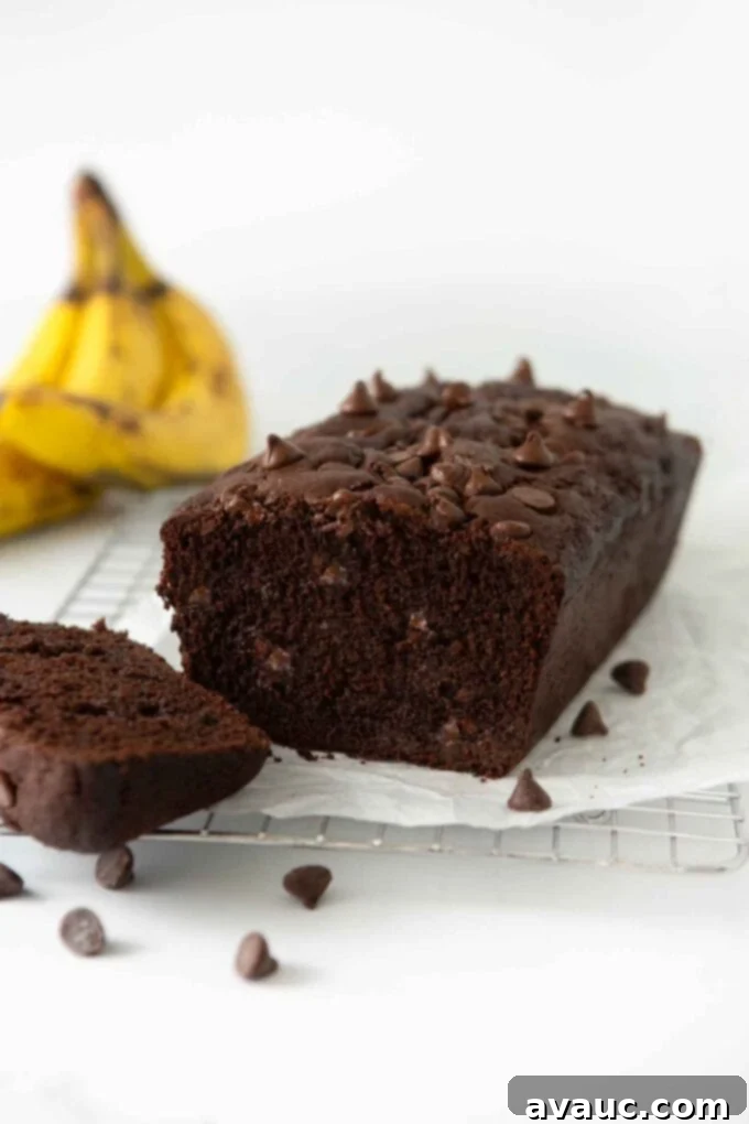 A freshly baked loaf of double chocolate banana bread on a cutting board, ready to be sliced and enjoyed.