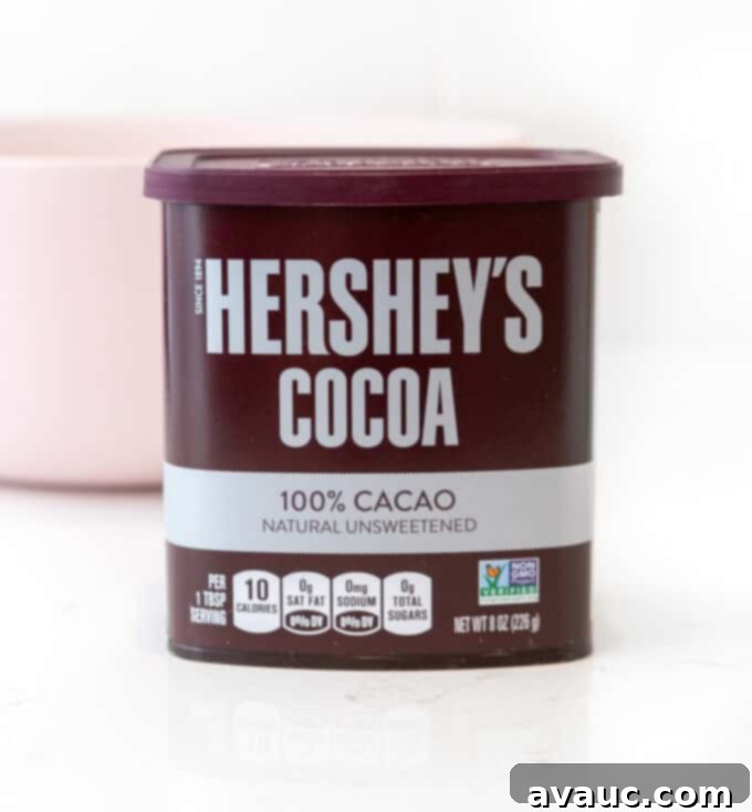 A container of Hershey's 100% natural unsweetened cocoa, a key ingredient for rich chocolate flavor in banana bread.