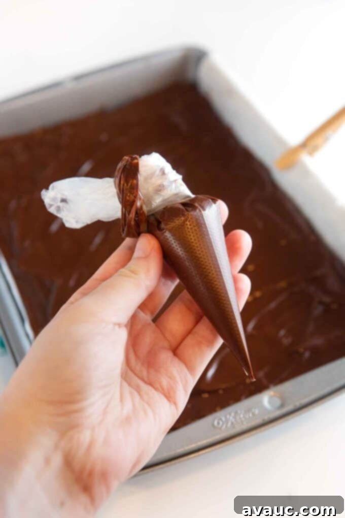 Decadent Thin Mint Cookie Bars 11 hand holding small piping bag of chocolate